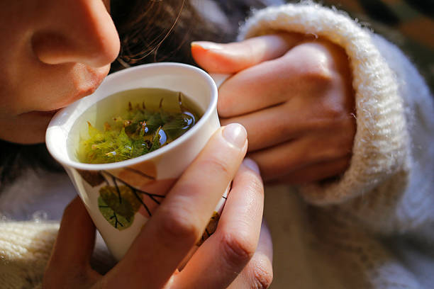 Woman enjoying a soothing cup of hot herbal tea