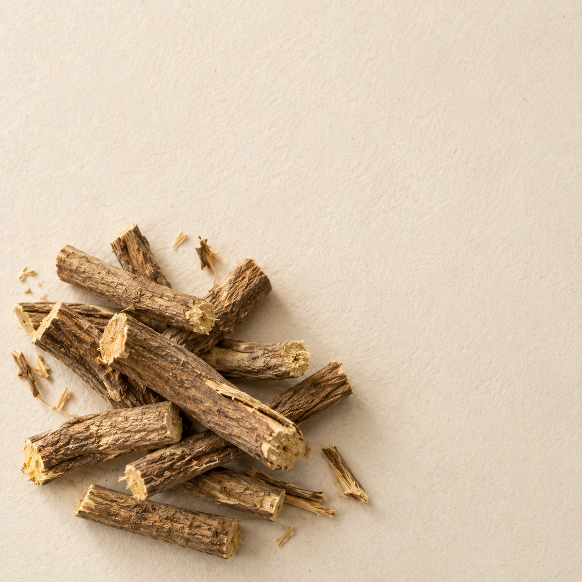 Cut sticks of dried licorice root, mulethi, showing fibrous brown bark and pale yellow interior