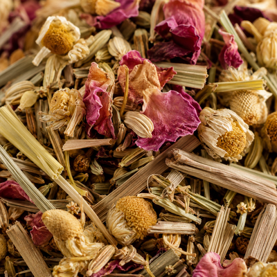 Dried chamomile flower heads with rose petals and lemongrass, the botanicals in UNWIND